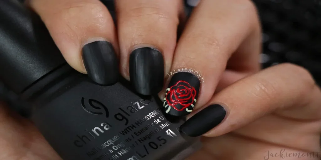 A close-up image of beautifully manicured hands featuring detailed rose nail art on each fingernail, showcasing a mix of vibrant colors and delicate floral patterns.